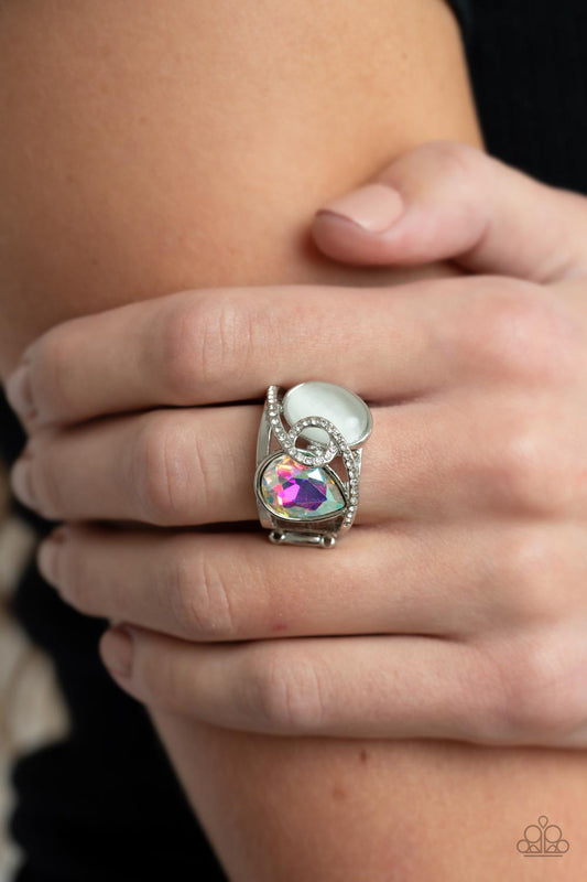 Paparazzi SELFIE-Indulgence - Multi Rhinestone Rings a white rhinestone dotted silver ribbon loops and slants over a tilted white cat's eye stone and iridescent teardrop gem, culminating into a stellar centerpiece. Features a stretchy band for a flexible fit.  Sold as one individual ring.