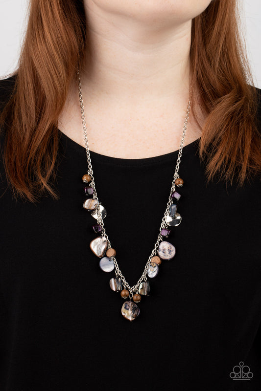 Paparazzi Accessories - Caribbean Charisma - Purple Necklaces a mismatched collection of warped silver discs, brown wooden beads, and iridescent shell-like rock accents dances from the bottom of a classic silver chain, creating a tropical sensation across the chest. Features an adjustable clasp closure.  Featured inside The Preview at GLOW!  Sold as one individual necklace. Includes one pair of matching earrings.