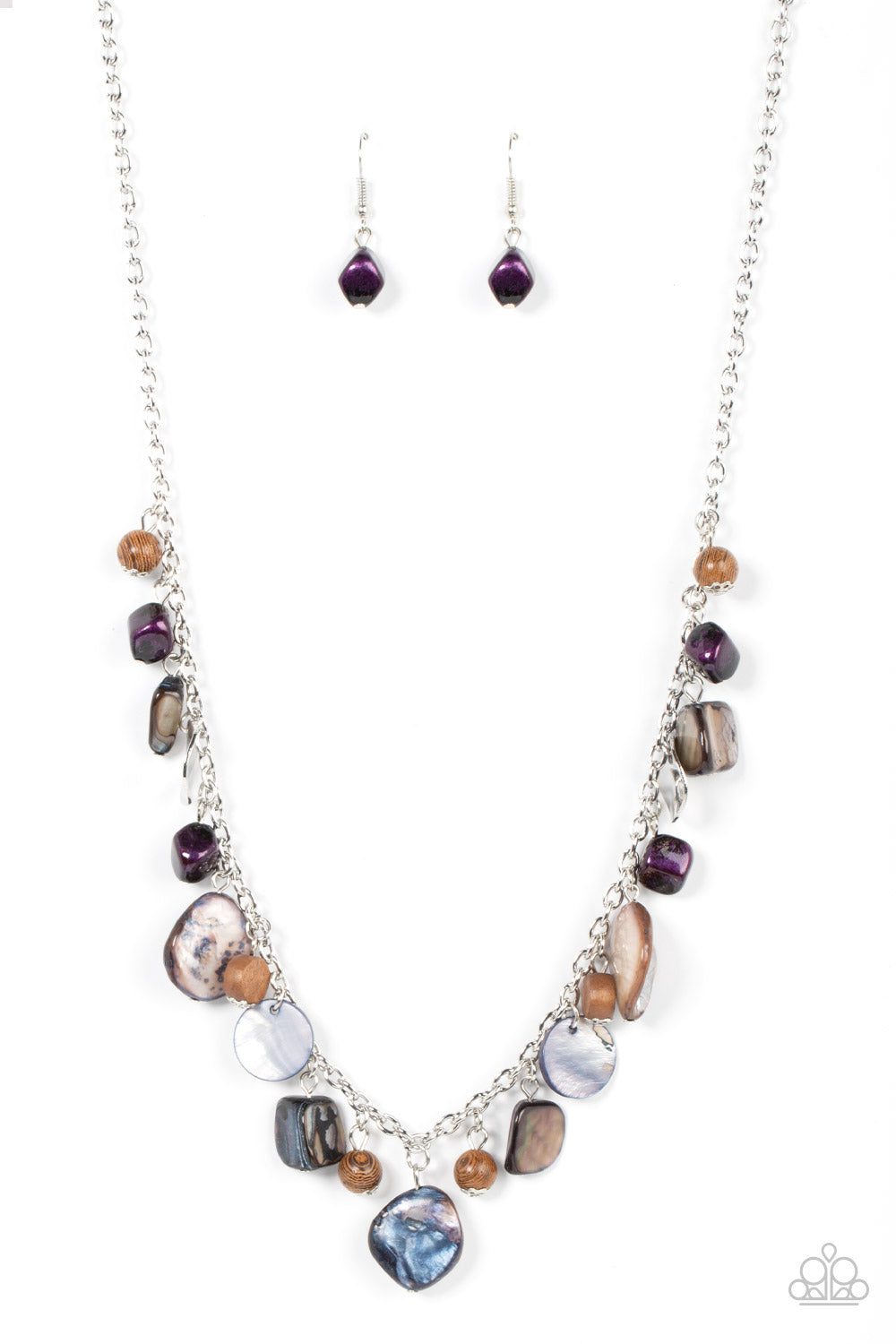 Paparazzi Accessories - Caribbean Charisma - Purple Necklaces a mismatched collection of warped silver discs, brown wooden beads, and iridescent shell-like rock accents dances from the bottom of a classic silver chain, creating a tropical sensation across the chest. Features an adjustable clasp closure. Featured inside The Preview at GLOW! Sold as one individual necklace. Includes one pair of matching earrings.