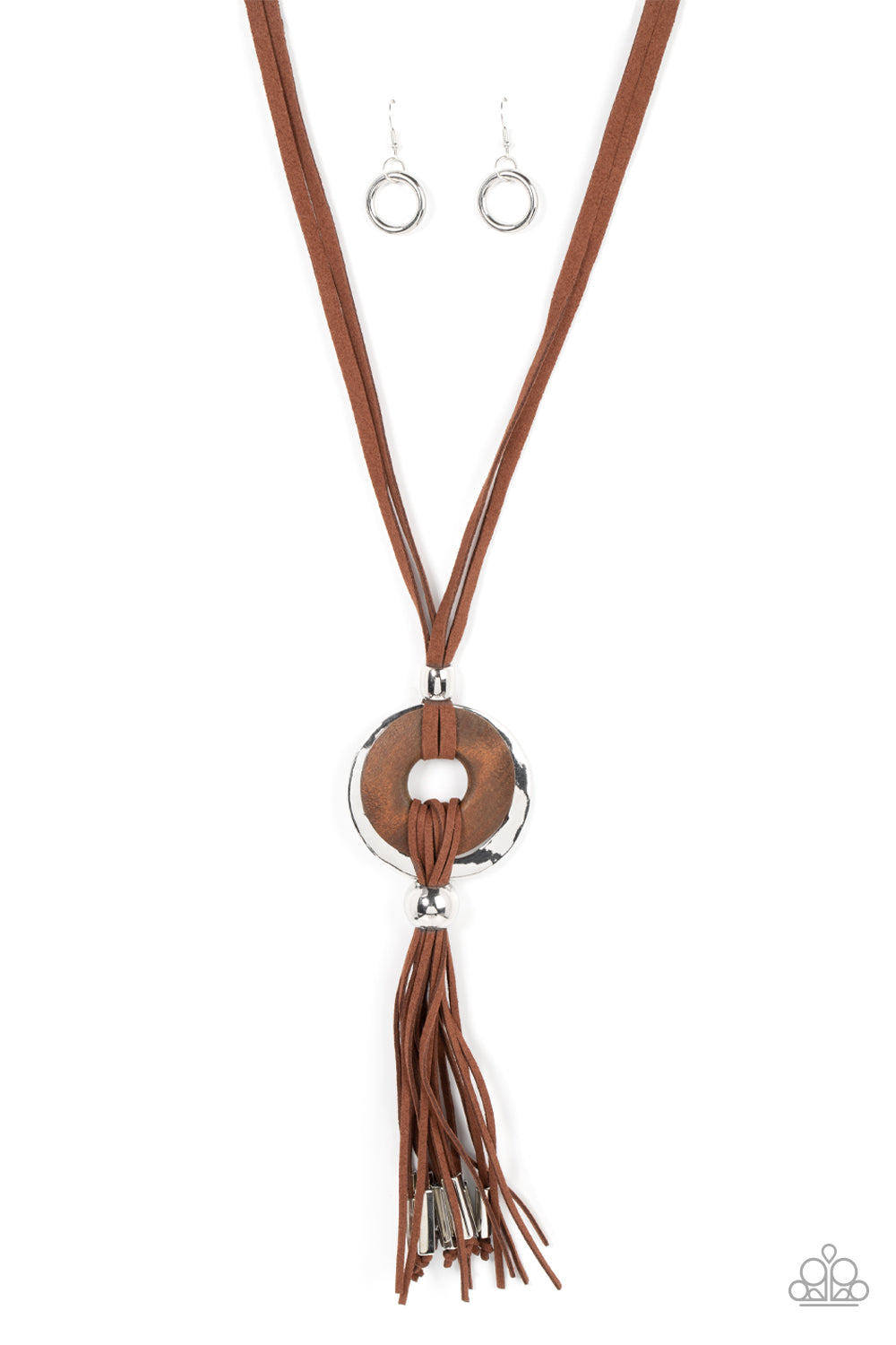 Loops of brown suede knot around a distressed wooden disc and hammered silver disc, resulting in a rustic pendant. The artisan inspired centerpiece gives way to a suede tassel capped in silver fittings, resulting in a noise-making fringe. Features an adjustable clasp closure. Sold as one individual necklace. Includes one pair of matching earrings.