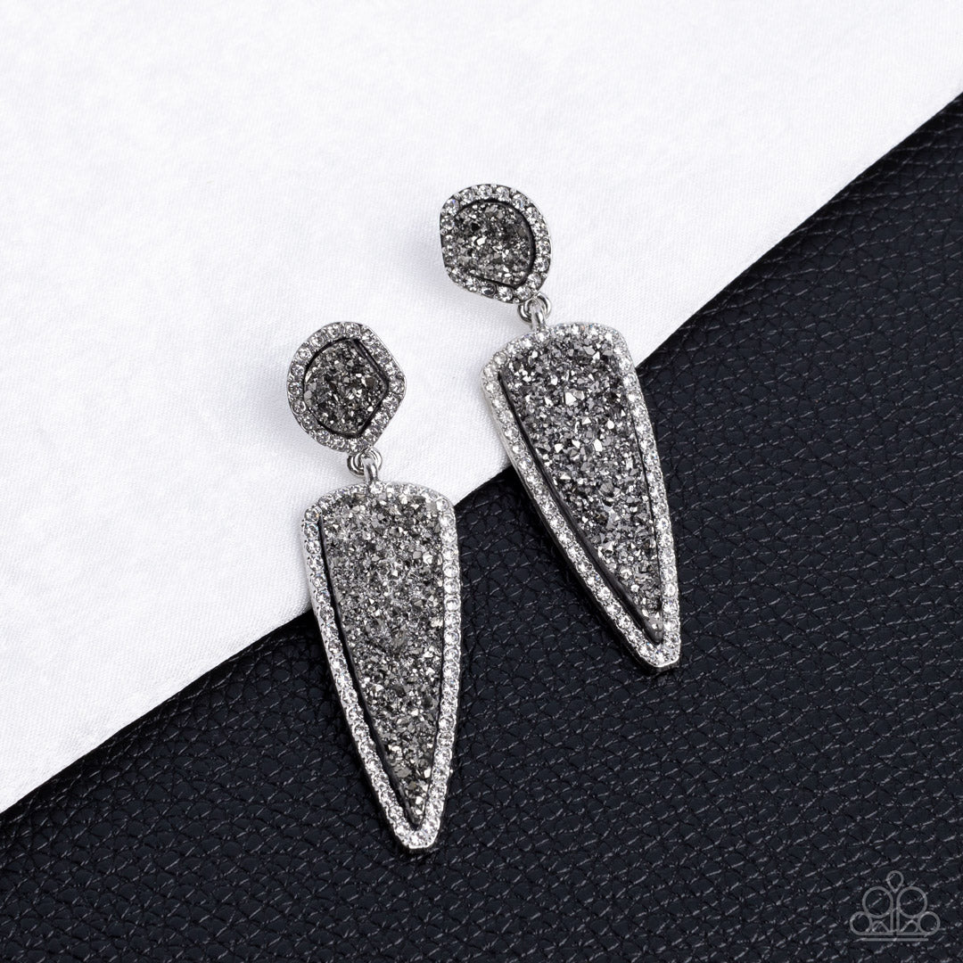 Paparazzi Accessories - Druzy Desire - Silver Rhinestone Earrings featuring asymmetrical and triangular cuts, a pair of black druzy-like accents are encased inside white rhinestone dotted silver frames as they link into a jaw-dropping lure. Earring attaches to a standard post fitting. Sold as one pair of post earrings.