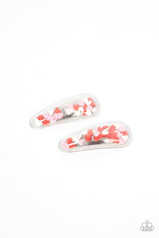 What a Sweetheart - Multi Heart Hair Clip a flirtatious collection of red, white, and pink hearts flutter back and forth inside a clear plastic frame, creating a charming eye-catching pop of color. Features standard snap hair clips on the back.  Sold as one pair of hair clips.