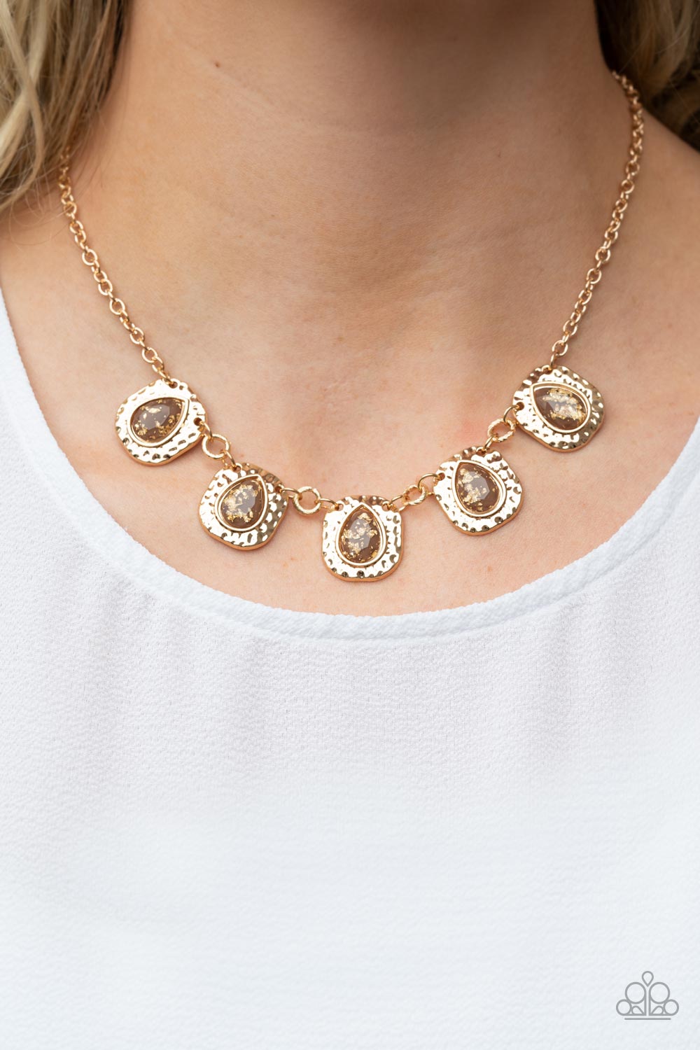 Paparazzi Accessories Mayan Masterpiece - Brown Hammered flecked in gold foil, glassy brown teardrops are pressed into hammered gold frames that delicately link below the collar for a dash of refined shimmer. Features an adjustable clasp closure.  Featured inside The Preview at GLOW!  Sold as one individual necklace. Includes one pair of matching earrings.