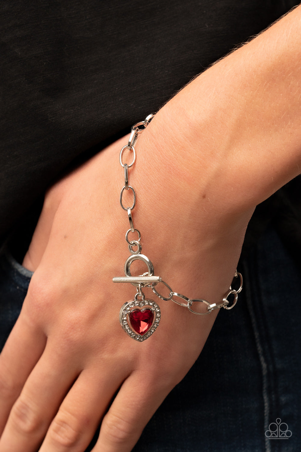 Til DAZZLE Do Us Part - Red Heart Toggle Bracelets bordered in glassy white rhinestones, a red heart shaped gem sparkles from a toggle closure at the center of an oval silver linked chain for a flirtatious fashion around the wrist. Features a toggle closure. Sold as one individual bracelet.