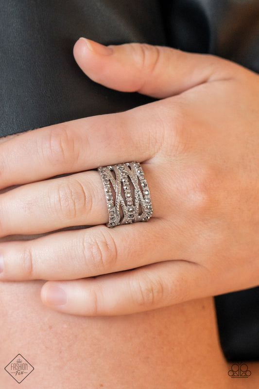 Paparazzi Unthinkable Twinkle - Silver Hematite Ring uneven rows of hematite rhinestones and hammered silver bands layer and crisscross across the finger, resulting in gritty glitz atop the finger. Features a stretchy band for a flexible fit.  Sold as one individual ring.  Fashion Fix February 2022