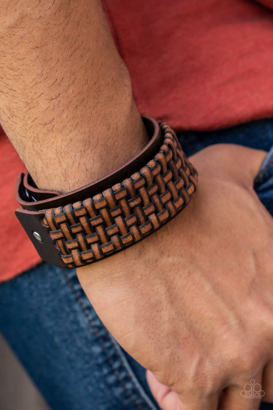 Paparazzi Accessories Urban Expansion - Brown Urban Leather Convention Bracelets distressed leather laces weave into a wicker-like pattern, creating a thick band of texture that wraps around a leather band. The textured overlay is studded in place across the front of the brown leather band, resulting in a rustic centerpiece. Features an adjustable snap closure.  Sold as one individual bracelet.  2022 Glow Convention