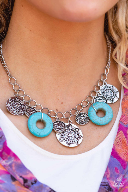 Paparazzi Accessories Western Zen - Blue Stone Convention Necklaces a collection of silver discs, embellished with intricate mandala-like designs, dances along a thick silver chain, with a pair of polished turquoise stone rings adding a pop of color to the rustic design. Features an adjustable clasp closure.  Sold as one individual necklace. Includes one pair of matching earrings.  2022 GLOW Convention Necklaces
