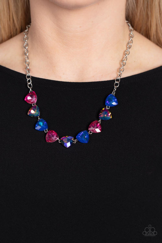 Paparazzi Accessories - Dreamy Drama - Blue EMP 2023 Necklaces a collection of dreamy trilliant-cut rhinestones in iridescent shades of blue and pink fall in line along the collar in a majestic finish. Features an adjustable clasp closure. Due to its prismatic palette, color may vary.  Sold as one individual necklace. Includes one pair of matching earrings.