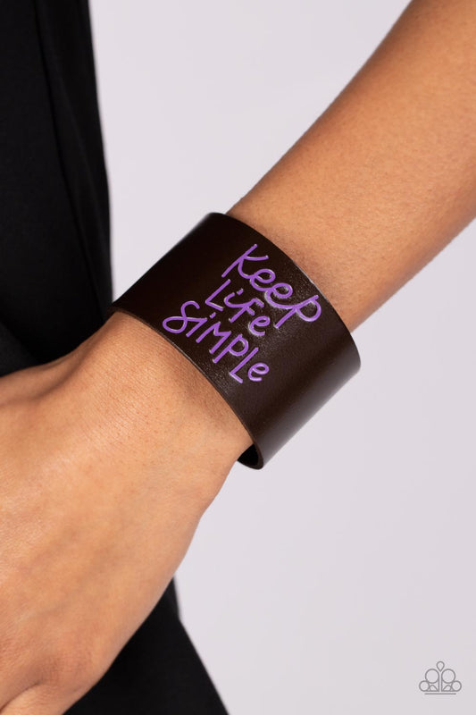 Paparazzi Accessories - Simply Stunning - Purple Inspirational Bracelets a thick band of dark brown leather is stamped in the phrase, "Keep Life Simple," in purple script. The playful font emphasizes the lighthearted message as the band wraps around the wrist in a casual finish. Features an adjustable snap closure.  Sold as one individual bracelet.