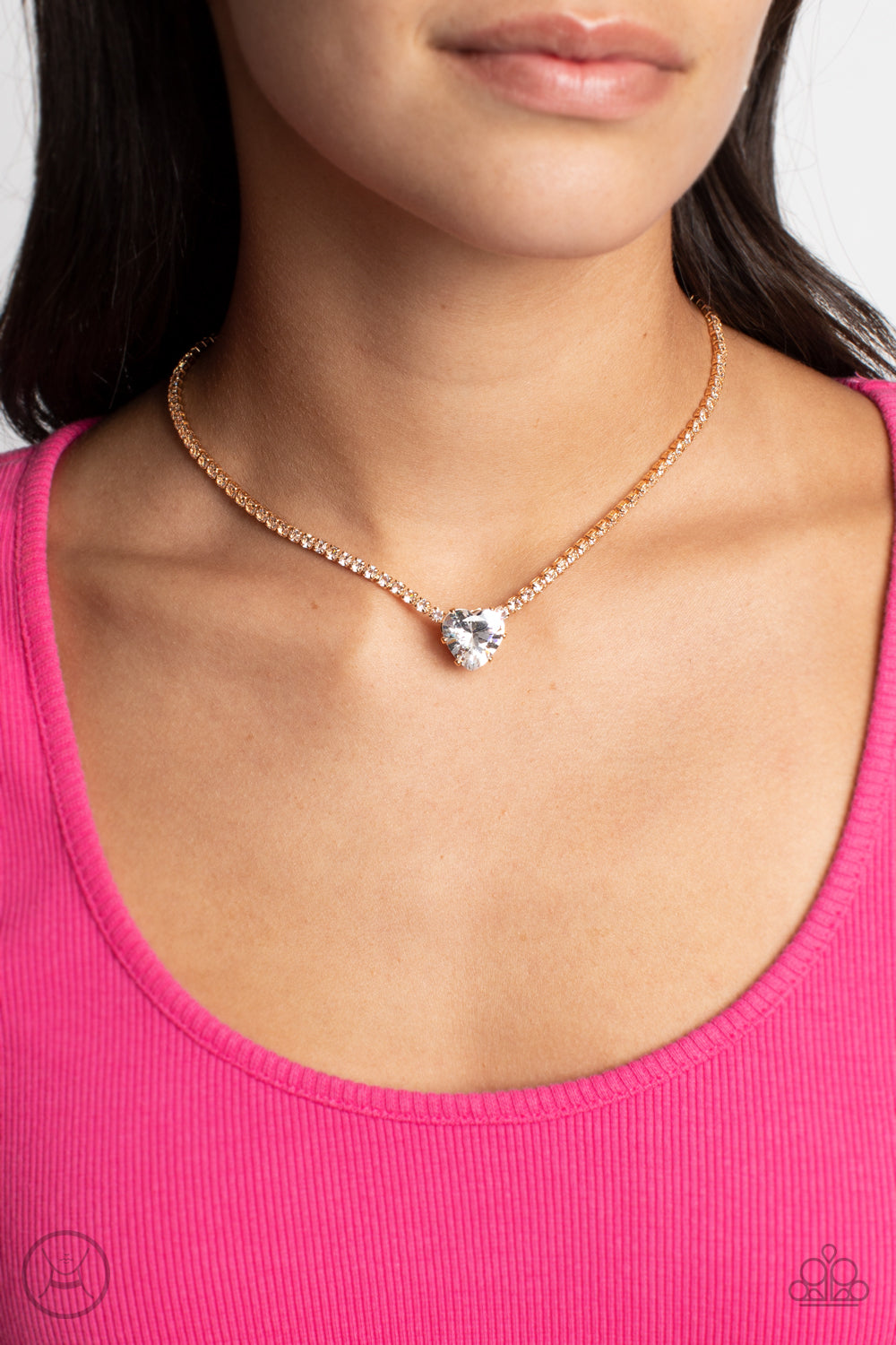 Paparazzi Accessories - Flirty Fiancé and Bedazzled Beauty - Gold Heart Set an oversized white heart-shaped gem, set in an airy, pronged gold fitting, glitters at the center of a blinding row of dainty, glassy white rhinestones set in square gold fittings, resulting in a flirtatious sparkle around the neckline. A heart-shaped gem, set in an airy, pronged gold fitting, glitters at the center of a blinding row of dainty, glassy white rhinestones set in square gold fittings, resulting in a flirtatious sparkle.