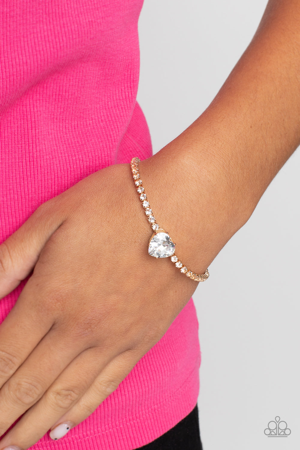 Paparazzi Accessories - Flirty Fiancé and Bedazzled Beauty - Gold Heart Set an oversized white heart-shaped gem, set in an airy, pronged gold fitting, glitters at the center of a blinding row of dainty, glassy white rhinestones set in square gold fittings, resulting in a flirtatious sparkle around the neckline. A heart-shaped gem, set in an airy, pronged gold fitting, glitters at the center of a blinding row of dainty, glassy white rhinestones set in square gold fittings, resulting in a flirtatious sparkle.