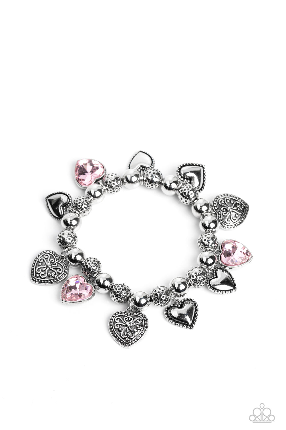 Paparazzi Accessories - Charming Crush - Pink Heart Bracelets decorative silver filigree, silver-studded, and pink gem heart charms swing from a collection of shiny silver beads, and silver beads with a dot motif. Threaded along an elastic stretchy band, the charming bracelet creates a timeless romantic centerpiece around the wrist. Sold as one individual bracelet.