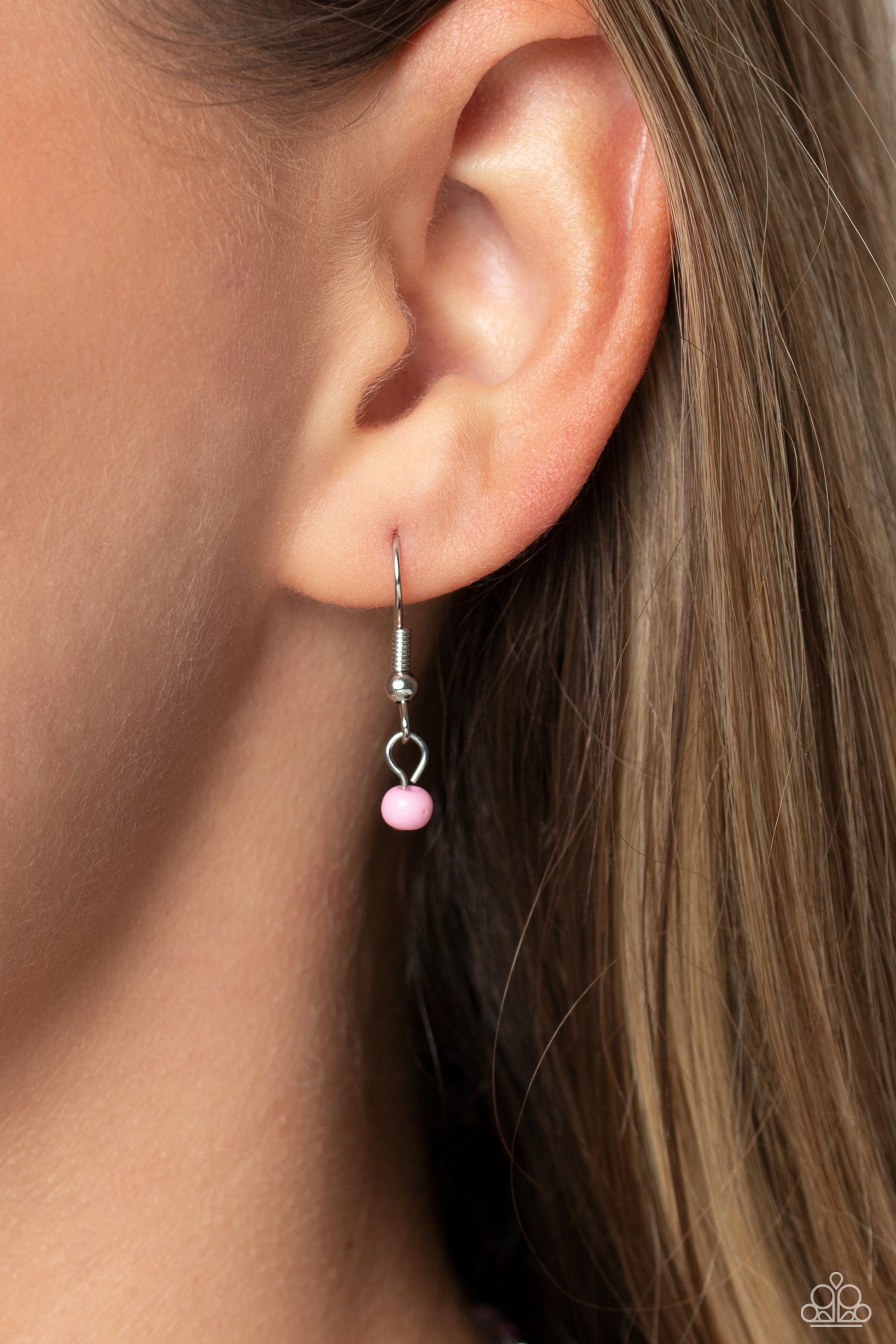 Paparazzi Accessories - High School Reunion - Pink Smiley Necklace Gliding from a dainty, silver chain, a smiley face pendant stands out against a pink backdrop. Completing the charismatic ensemble, a collection of seed beads in shades of light pink, white, pink, orange, and hot pink create bright pops of color around the neckline for a youthful finish. Features an adjustable clasp closure.  Sold as one individual necklace. Includes one pair of matching earrings.