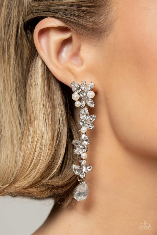 Paparazzi Accessories - LIGHT at the Opera - White 2023 EMP Earrings radiant clusters of white reflective teardrop, marquise-cut and round gems combine with classic white pearls to create an explosion of glitz that extends down the ear. Hanging from the bottom of the light-reflecting earring, a white, reflective teardrop gem swings for some eye-catching shimmer against a backdrop of high-sheen silver. Earring attaches to a standard post fitting.