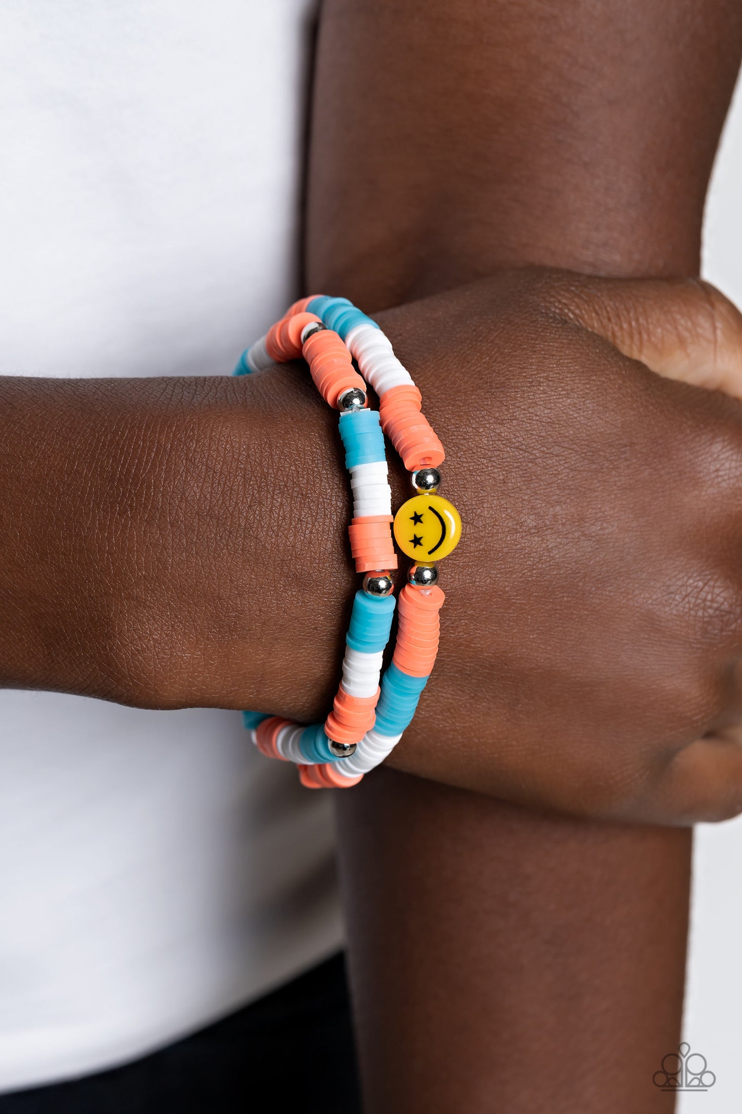 Paparazzi Accessories - In SMILE - Orange Smiley Bracelets coral, blue, and white rubber discs combine with sporadically placed silver beads to provide a vibrant pop of color along the wrist. Meeting in the center of one of the multi-shaded bracelets, a yellow bead with a smiley face, featuring stars for eyes, rests for a youthful finish. Sold as one set of two bracelets.