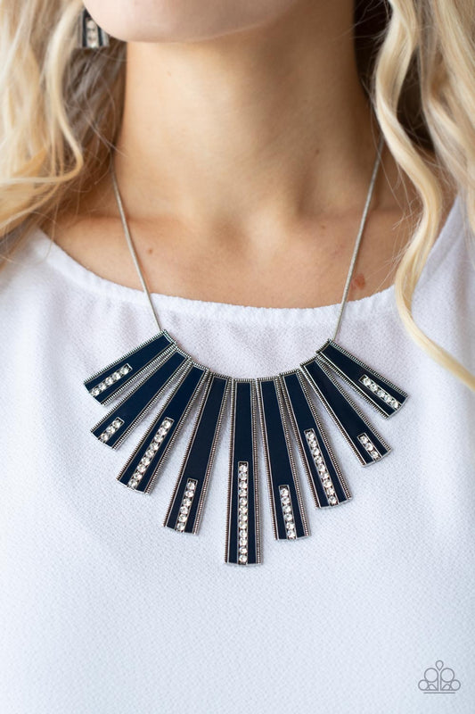 FAN-tastically Deco - Blue Necklaces encased in daintily dotted silver frames, a row of flared silver bars painted in a glossy Navy Blue fans out across the collar. A column of sparkling white rhinestones rises from the bottom of each frame, creating a dramatically deco finish as they sway from a round silver chain. Features an adjustable clasp closure.  Sold as one individual necklace. Includes one pair of matching earrings.  Paparazzi Jewelry is lead and nickel free so it's perfect for sensitive skin too!