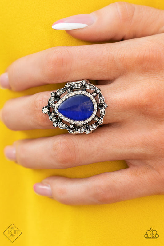 Iridescently Icy - Blue Ring dotted in glittery white rhinestones, leafy silver frames nestle around a glowing Classic Blue cat's eye teardrop center, creating a regal centerpiece atop the finger. Features a stretchy band for a flexible fit.  Sold as one individual ring.