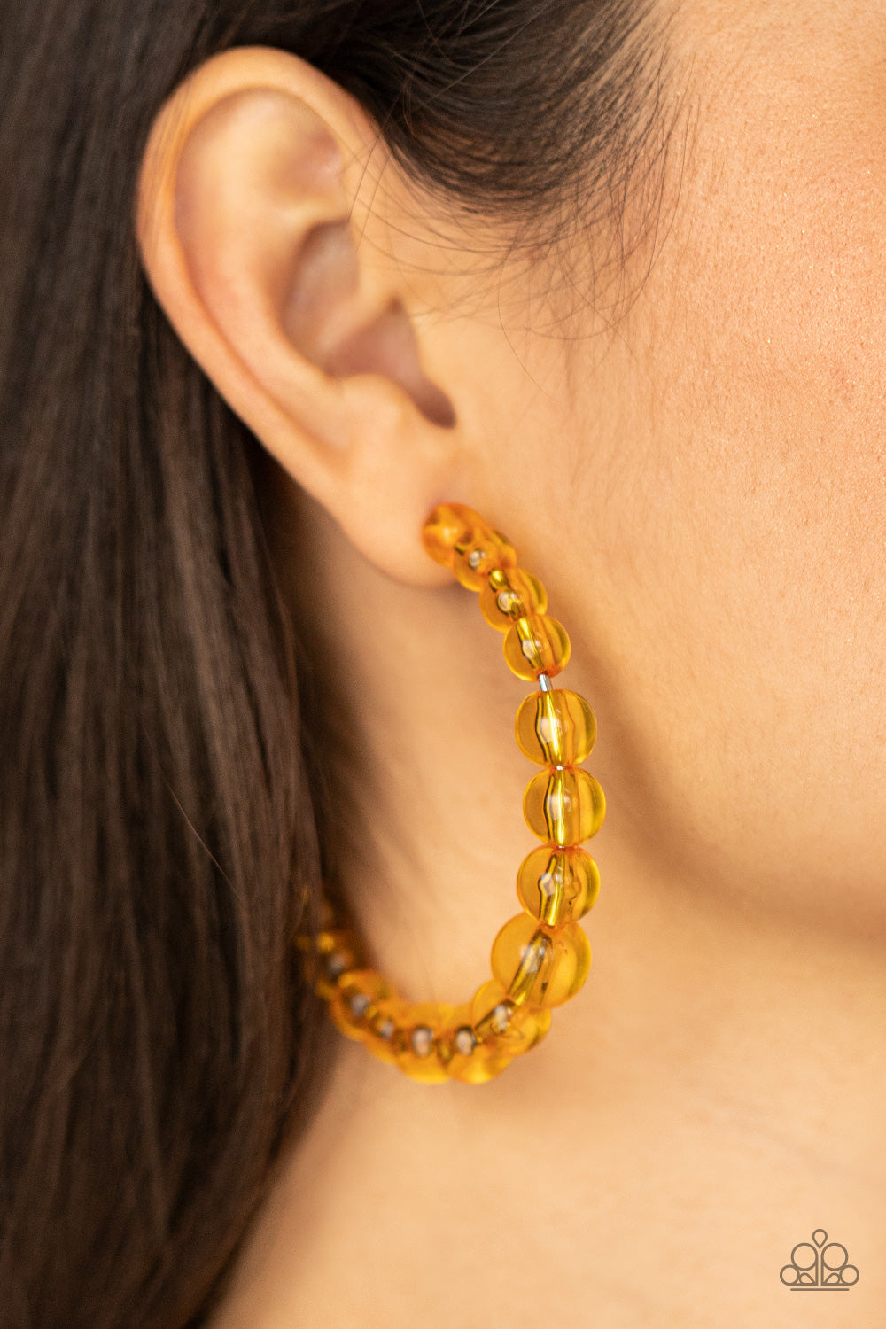 Paparazzi Accessories In the Clear - Orange Hoop Earrings gradually increasing in size at the center, a glassy collection of Marigold beads are threaded along an oversized hoop for a bubbly effect. Earring attaches to a stand post fitting. Hoop measures approximately 2 1/2" in diameter.  Sold as one pair of hoop earrings.  Paparazzi Jewelry is lead and nickel free so it's perfect for sensitive skin too!