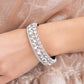 Mega Megawatt - White Rhinestone Life of the Party Bracelets three blinding rows of mismatched white rhinestones dramatically stack across the wrist, coalescing into a majestic bangle-like centerpiece. Features a hinged closure.  Sold as one individual bracelet.