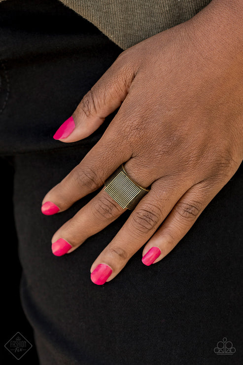 Etched in linear texture, a bold brass square sits atop a thick brass band radiating with alternating linear patterns, creating an edgy centerpiece. Features a stretchy band for a flexible fit.  Sold as one individual ring.