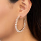 Paparazzi Accessories - Halo Hustle - Gold Hoop Earrings threaded along a dainty gold wire, an iridescent collection of glassy white crystal-like beads wrap around the front of a classic gold hoop for an unexpected pop of shimmer. Hoop measures approximately 1 3/4" in diameter.  Sold as one pair of hoop earrings.