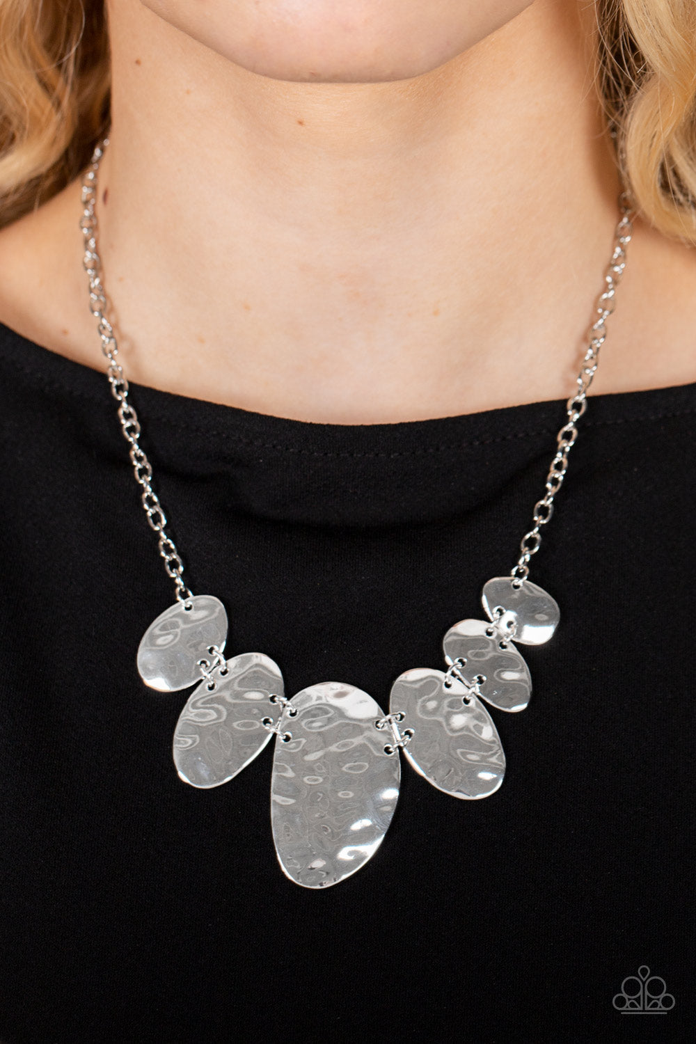 Paparazzi Accessories - Cave Crawl - Silver Necklaces hammered in eye-catching textures, a glistening collection of asymmetrical silver ovals gradually increase in size as they delicately link below the collar for an artisan inspired fashion. Features an adjustable clasp closure.  Sold as one individual necklace. Includes one pair of matching earrings.