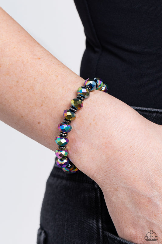 Paparazzi Accessories - Shimmering Satisfaction - Multi Bracelets fipped in metallic shimmer, glittery oil spill crystal-like beads and studded gunmetal rings are threaded along a stretchy band around the wrist for a stellar fashion.  Sold as one individual bracelet.