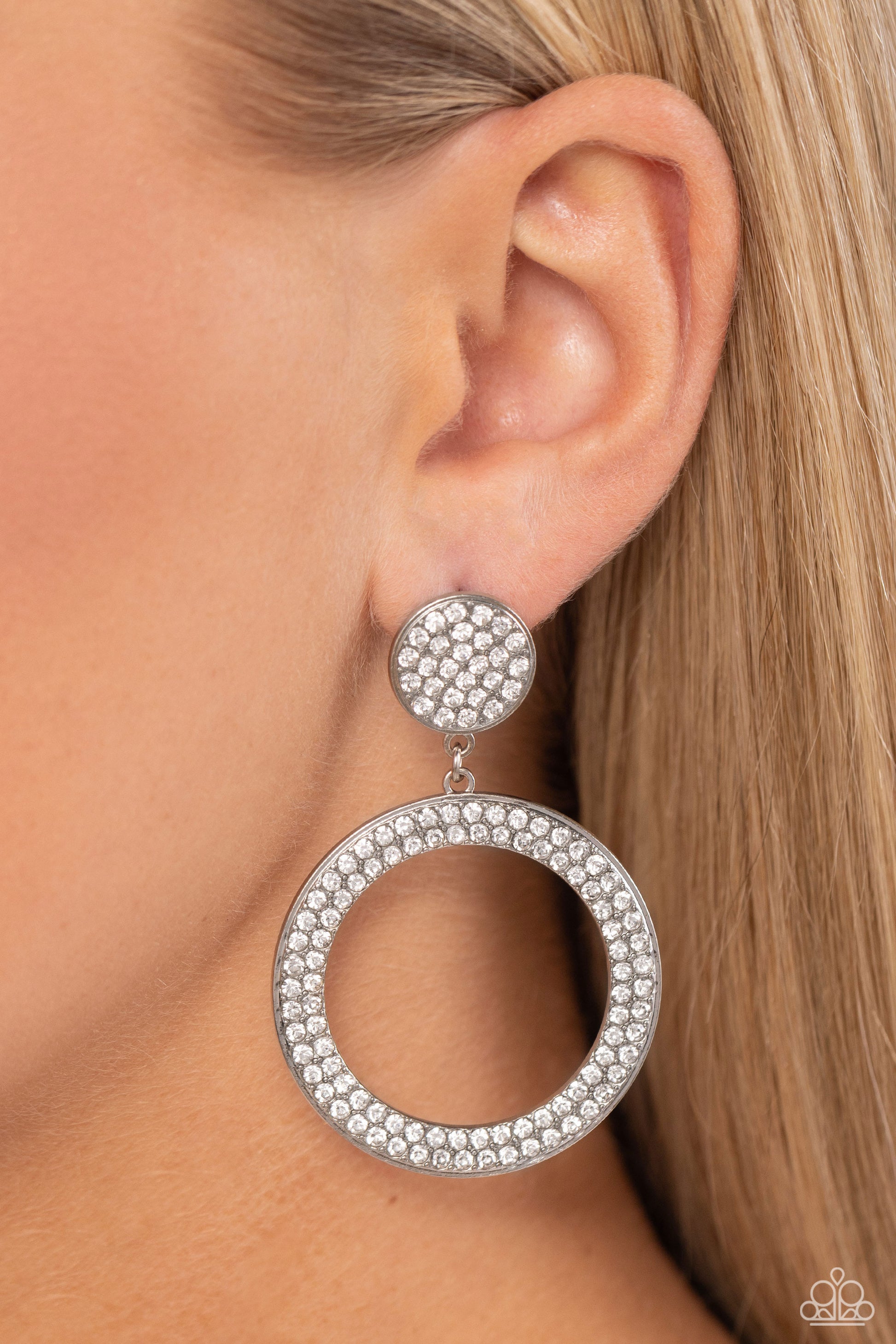 Paparazzi Accessories - GLOW You Away - White Earrings encrusted in rows of glassy white rhinestones, a flat silver hoop swings from the bottom of a white rhinestone dotted silver frame for a statement-making finish. Earring attaches to a standard post fitting.  Sold as one pair of post earrings.