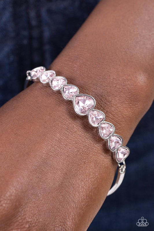 Paparazzi Accessories - Lusty Luster - Pink Heart Bracelets attached to silver bars, a sparkling series of heart cut Gossamer Pink gems are encased in glistening silver frames that curve into a flirtatious centerpiece atop the wrist. Features an adjustable clasp closure.  Sold as one individual bracelet.