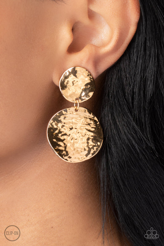 Paparazzi Accessories - Rush Hour - Gold Clip-on Earrings hammered with high-sheen texture, warped gold discs delicately link into a bold monochromatic statement piece. Earring attaches to a standard clip-on fitting.  Sold as one pair of clip-on earrings.