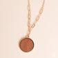 Paparazzi Accessories - WOODnt Dream of It - Gold Necklaces a circular piece of wood is nestled inside a simple gold fitting along a mismatched gold chain, creating an earthy pendant below the collar. Features an adjustable clasp closure.  Sold as one individual necklace. Includes one pair of matching earrings.