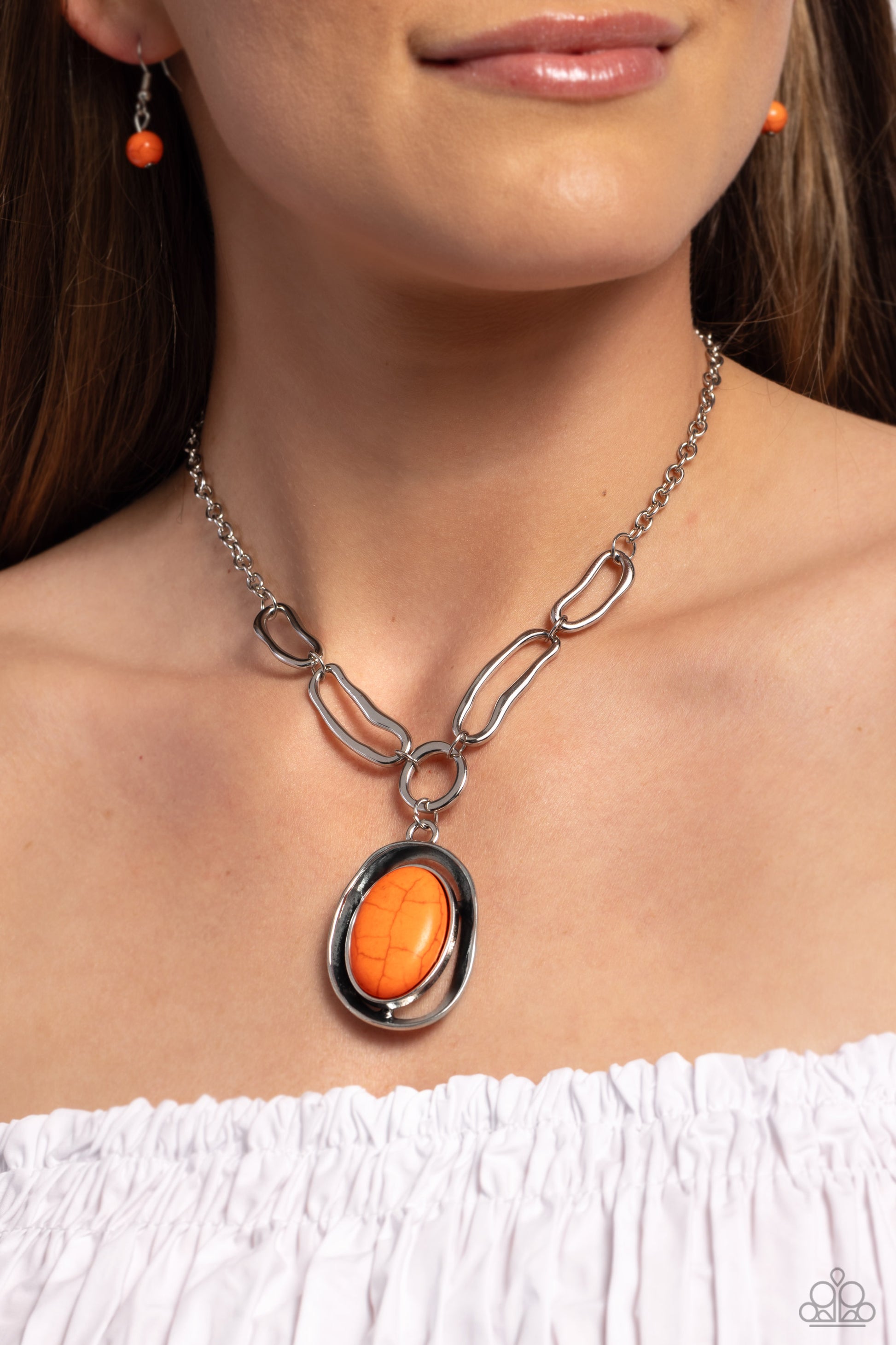 Paparazzi Accessories - Sandstone Stroll - Orange Necklaces a silver links give way to an exaggerated orange stone encased in a rippling silver frame with irregular borders, to create a bold focal point. Features an adjustable clasp closure. As the stone elements in this piece are natural, some color variation is normal.  Featured inside The Preview at Made for More! Sold as one individual necklace. Includes one pair of matching earrings.