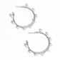 Paparazzi Accessories - Night at The Gala - White Pearl Earrings a classy collection of dainty white pearls are wrapped along the outside curve of a shiny, silver hoop by shimmery silver wire for a handcrafted, posh finish. Earring attaches to a standard post fitting. Hoop measures approximately 1 1/4" in diameter.  Sold as one pair of hoop earrings.