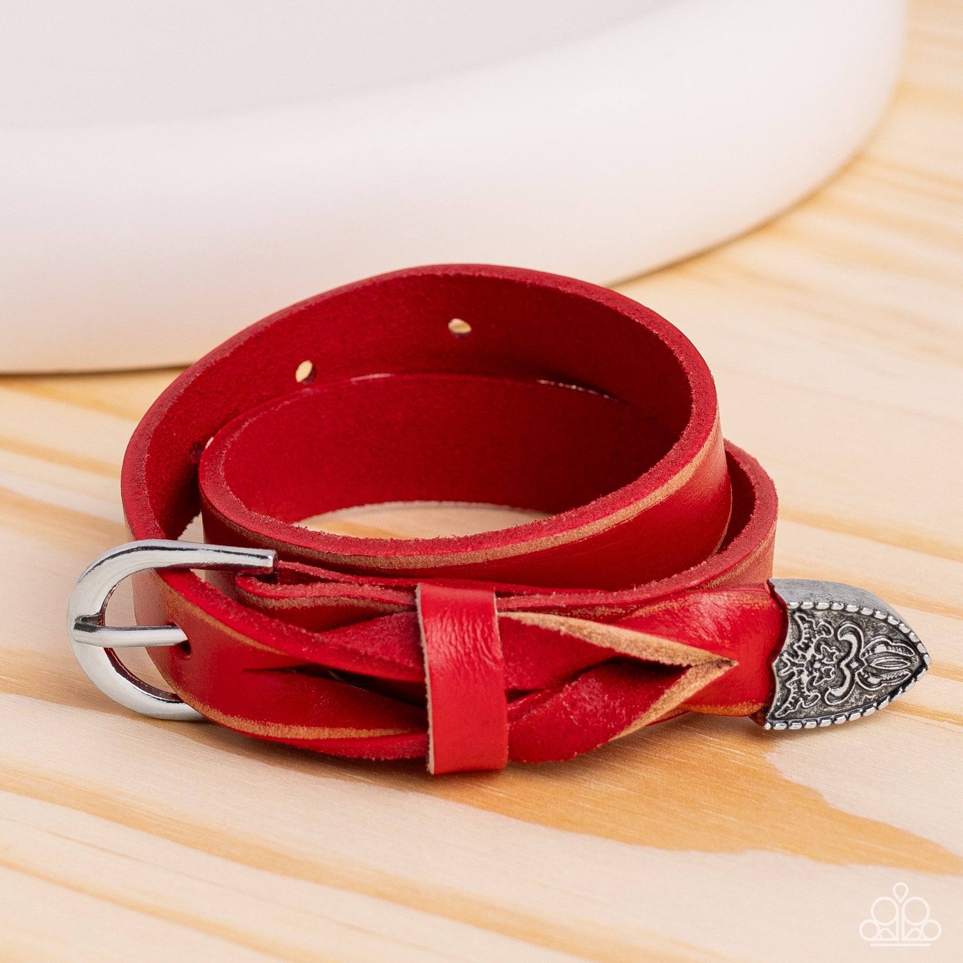 Paparazzi Accessories - Coat of Arms - Red Braceleloofeaturing a weathered finish, a red leather band loops around the wrist in a belt loop fashion. Featured at the end of the loop, the leather braids into a silver cap fitting, embossed with a coat of arms style filigree for an urban statement. Features an adjustable belt loop closure.  Featured inside The Preview at Made for More!  Sold as one individual bracelet.