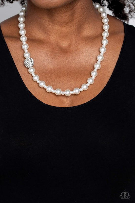 Paparazzi Accessories - Countess Chic - White Pearl Necklace strung along the entirety of an invisible wire, classic white pearls in varying sizes coalesce down the neckline for a refined finish. Adding to the elegant design, a sparkly white rhinestone-encrusted silver ornament shimmers amongst the sea of pearls. Features an adjustable clasp closure.  Sold as one individual necklace. Includes one pair of matching earrings.