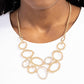 Paparazzi Accessories - Limelight Lead - Gold Necklaces oblong gold rings in varying sizes intermingle with oblong gold rings dusted with a border of white rhinestones for a sparkly monochromatic statement that cascades down the neckline from a classic gold chain. Features an adjustable clasp closure. Sold as one individual necklace. Includes one pair of matching earrings.