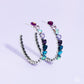 Paparazzi Accessories - Hypnotic Heart Attack - Multi June 2023 LOP Hoop Earrings Featuring a scalloped heart frame, glittery heart rhinestones in shades of pink, iridescence, purple, blue, and a refracted green shimmer slowly decrease in size as they curve down the ear to meet dainty silver hearts for a romantic statement. Earring attaches to a standard post fitting. Hoop measures approximately 1 3/4" in diameter. Due to its prismatic palette, color may vary.  Sold as one pair of hoop earrings.