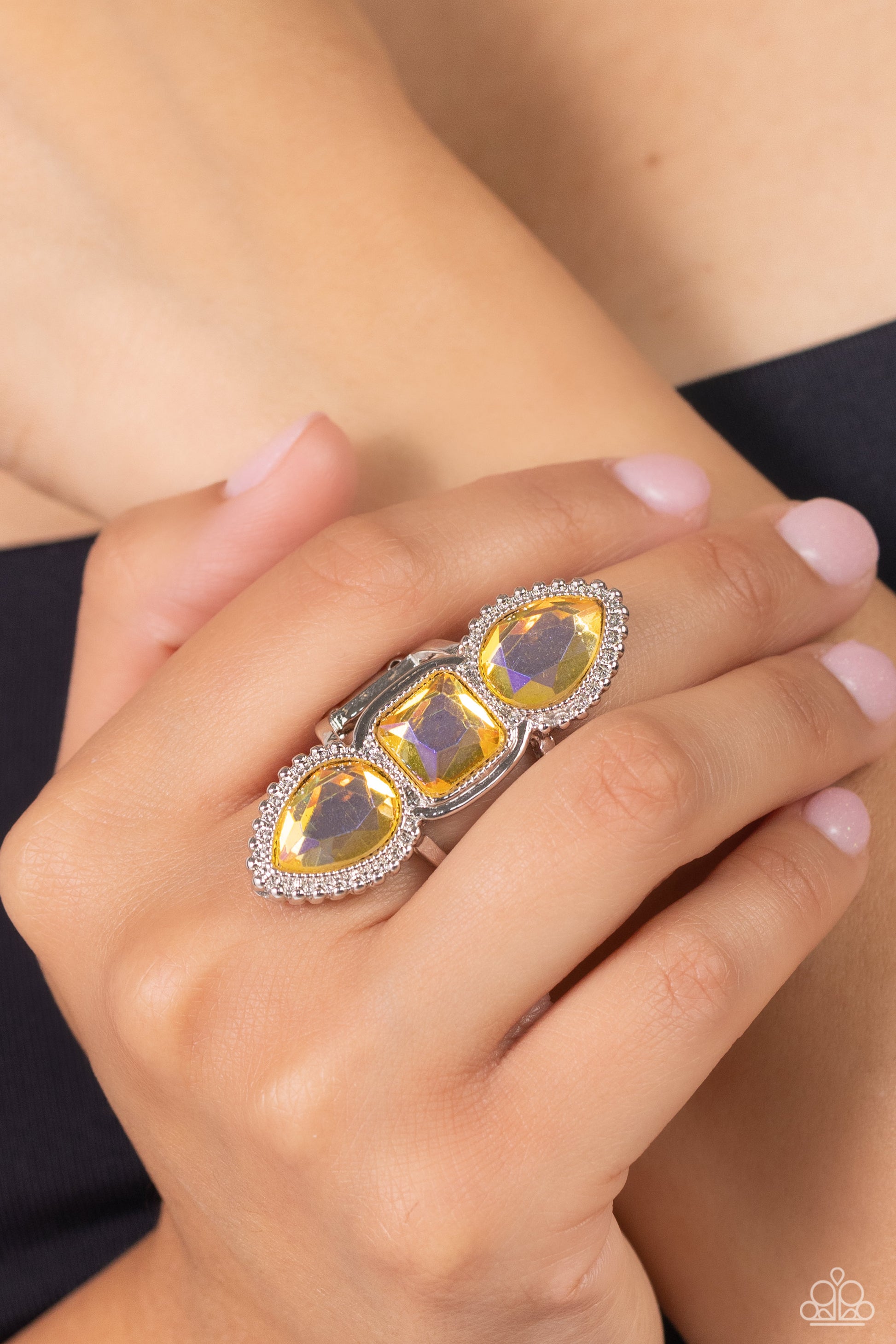 Paparazzi Accessories - Dazzling Direction - Yellow Ring featuring square and teardrop cuts, vivacious yellow gems with a reflective iridescence, are pressed into a studded and sleek silver frame, creating a stacked, grand display atop the finger. Airy silver bands anchor the blinding bling to the finger for additional whimsical detail. Features a stretchy band for a flexible fit. Due to its prismatic palette, color may vary.  Sold as one individual ring.  Order date 1/8/24