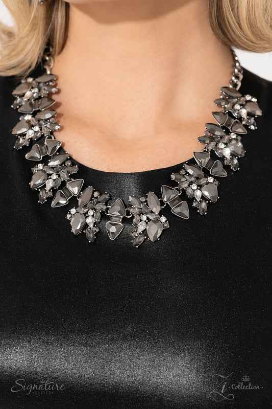Smoldering clusters of gleaming hematite and smoky sparkle erupt into an edgy exhibition along the collar. Each cluster is shaped by teardrop- and marquise-cut gems, exaggerated by pronged fittings as they collide with classic white rhinestones. Between each gritty grouping, an emerald-cut gem separates triangular cuts of hematite that point in opposite directions, adding even more attitude to the angular arrangement as light scatters from every faceted surface. Features an adjustable clasp closure.