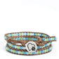 Paparazzi Accessories - PAW-sitive Thinking - Blue Bracelets infused with an antiqued heart and pawprint embossed button, a row of blue and green multicolored cloudy and milky beads are knotted in place along two brown leather cords, creating multiple earthy layers around the wrist with its extended length. Features an adjustable button loop closure.  Sold as one individual bracelet.