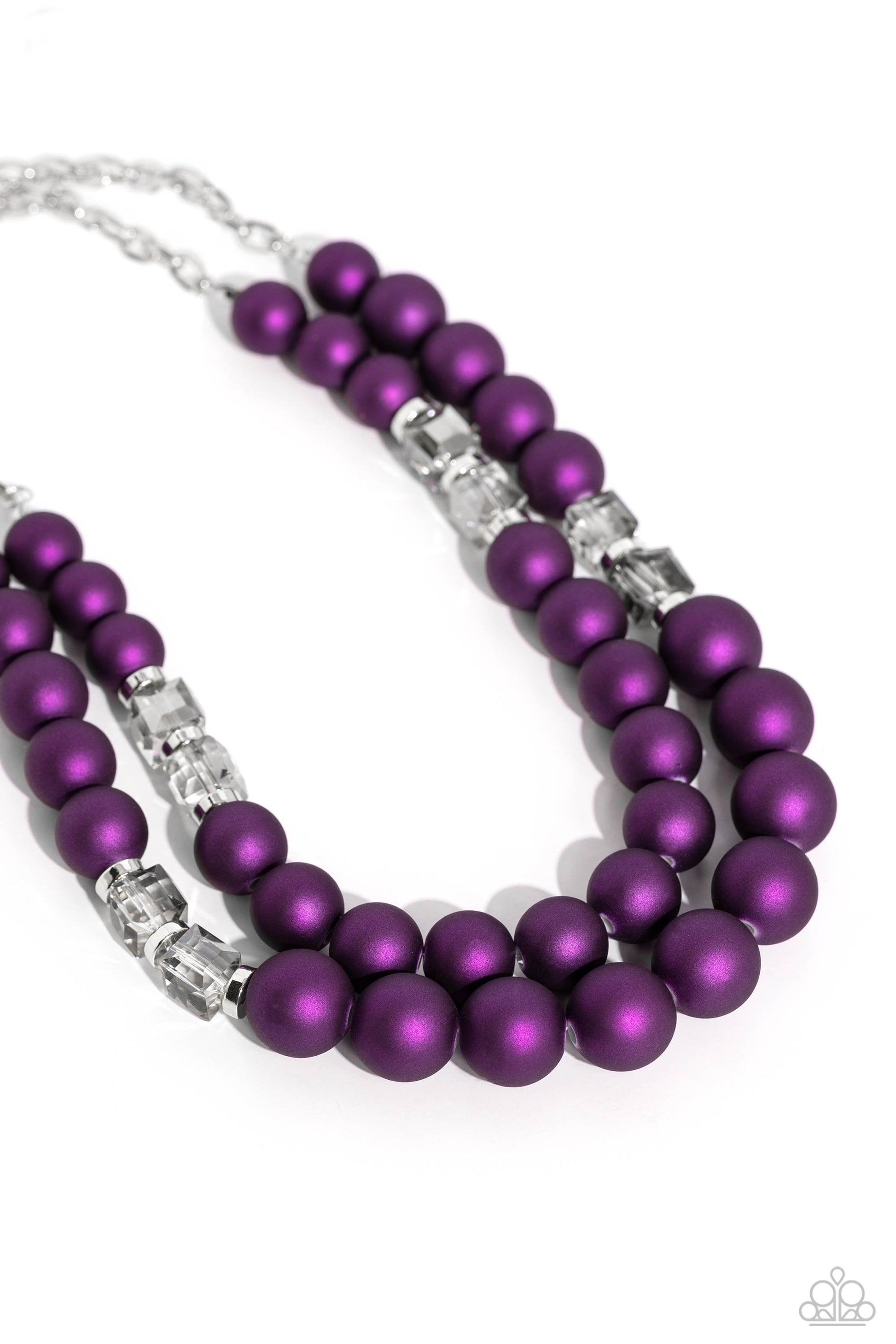 two rows of oversized purple beads featuring a subtle shimmer, silver accents, and clear gray cubed beads fall below the collar on silver paperclip chains, creating refined, colorful layers. Features an adjustable clasp closure. Sold as one individual necklace. Includes one pair of matching earrings. Two strands of oversized purple beads featuring a subtle shimmer, silver accents, and clear gray cubed beads stretch around the wrist, creating refined, colorful layers.