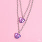 Paparazzi Accessories - Layered Love - Purple Heart Necklaces featuring a subtle iridescent shimmer, two glassy purple gem hearts are delicately suspended above one another on a paperclip and silver oval link chain for a whimsical double-stacked display. Features an adjustable clasp closure.  Sold as one individual necklace. Includes one pair of matching earrings.