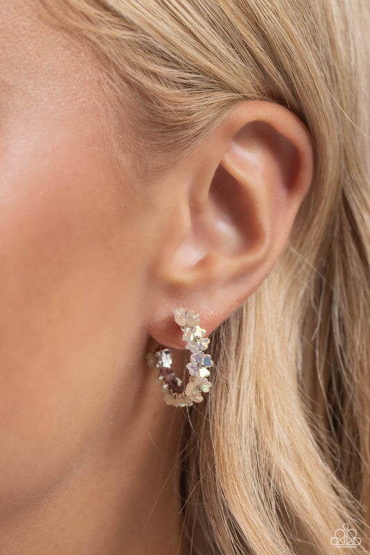 Paparazzi Accessories - Floral Focus - White Earrings tiny white iridescent flowers connect to one another as they wrap around the ear to create a charming, dainty hoop. Earring attaches to a standard post fitting. Hoop measures approximately 3/4" in diameter. Due to its prismatic palette, color may vary. Sold as one pair of hoop earrings.