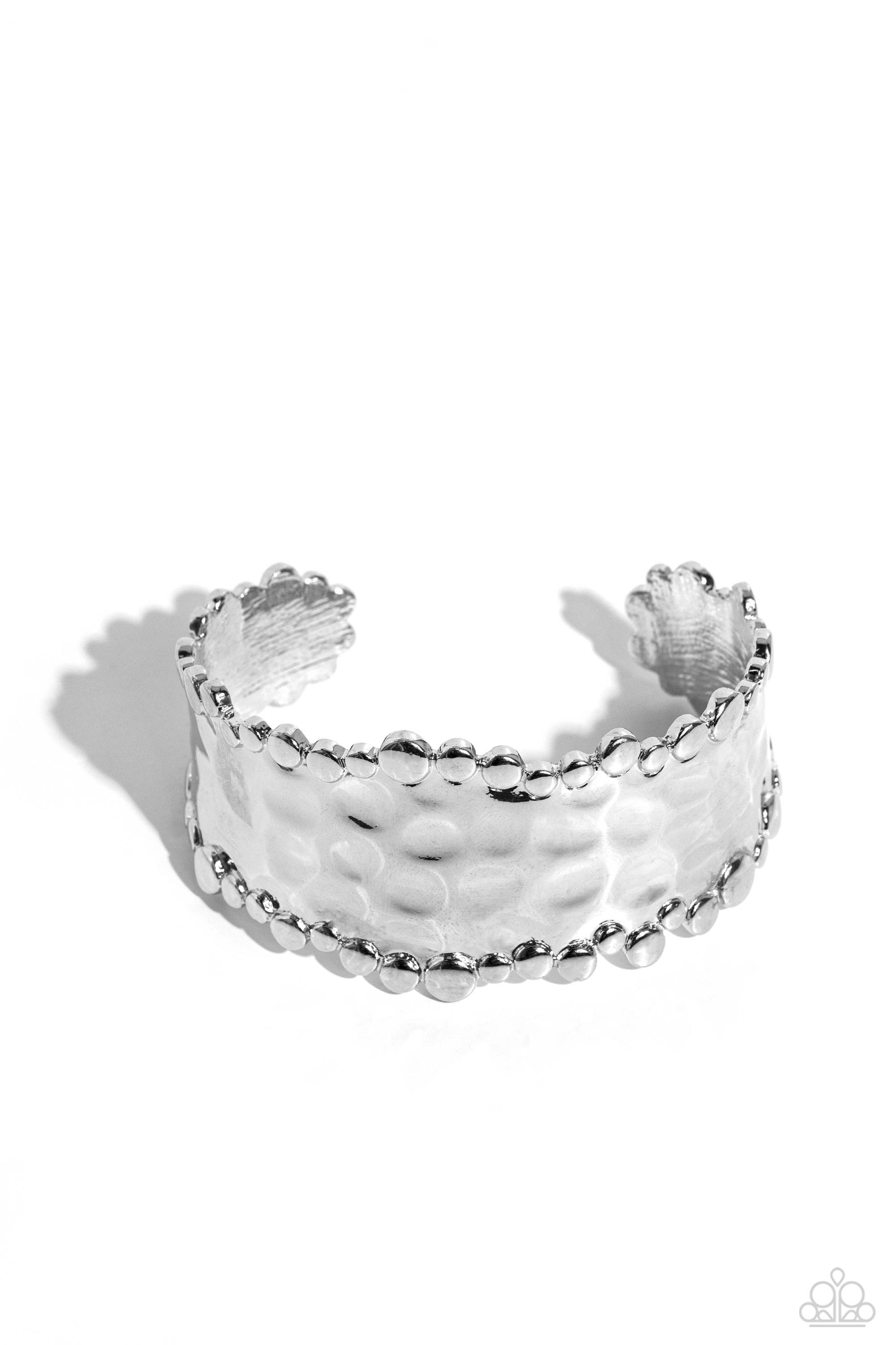 <p data-mce-fragment="1">Paparazzi Accessories - Handcrafted Haute - Silver Cuff Bracelets the top and bottom of a thick silver hammered cuff is haphazardly lined in various sizes of silver studs for a handcrafted finish.</p> <p data-mce-fragment="1"><i data-mce-fragment="1">Sold as one individual bracelet</i></p>