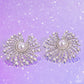 Paparazzi Accessories - Fancy Fireworks - December 2023 Life of the Party White Earrings shimmery strands of silver spin out from a white pearly center, creating an exaggerated firework-like display at the ear. An explosion of dainty iridescent rhinestones, dainty white pearls, and white rhinestones lines the swirls and curves of the shimmery display, creating an eye-catching display. Earring attaches to a standard post fitting. Due to its prismatic palette, color may vary.