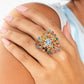 Paparazzi Accessories - Bewitching Beau - January 2024 Life of the Party - Multi Ring set in pronged gold square fittings, multicolored round rhinestones circle a light sapphire heart gem in a sunburst pattern for a bewitching display. Features a stretchy band for a flexible fit.  Sold as one individual ring.