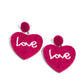 Paparazzi Accessories - Sweet Seeds - Pink Heart Earrings hot pink rows of dainty seed beads adorn the front of a heart frame at the bottom of a matching beaded fitting, creating a blissfully beaded look. The word "Love" is spelled out in white seed beads across the center of the heart frame for a romantic finish. Earring attaches to a standard post fitting.  Sold as one pair of post earrings.