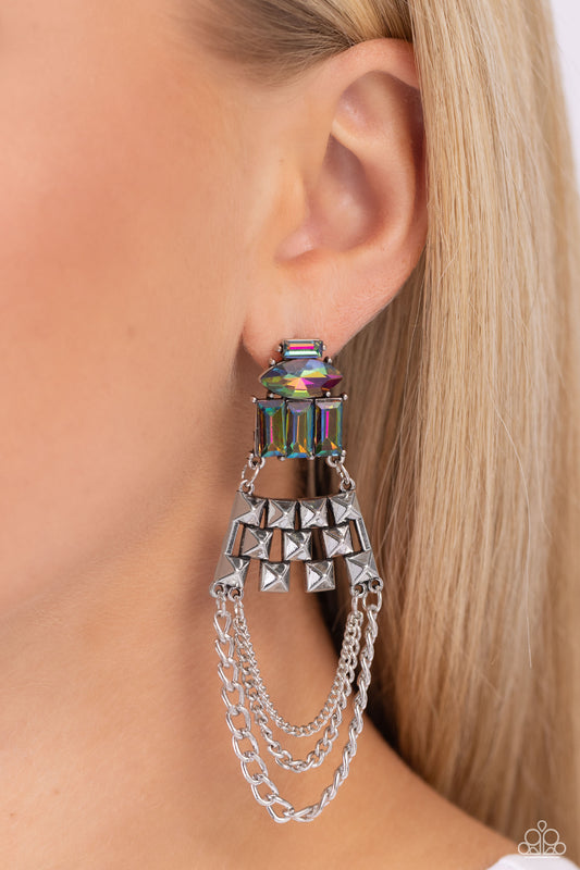 Paparazzi Accessories - Dangling Art Deco - Multi Earrings featuring silver pronged fittings, a collection of emerald-cut and marquise-cut oil spill beads layer atop one another, connecting to a haphazard pattern of silver squares that come to a point. Mismatched silver chains swing from the bottom of the spiked silver fittings, creating an edgy art-deco-inspired chandelier. Earring attaches to a standard post fitting.  Sold as one pair of post earrings.