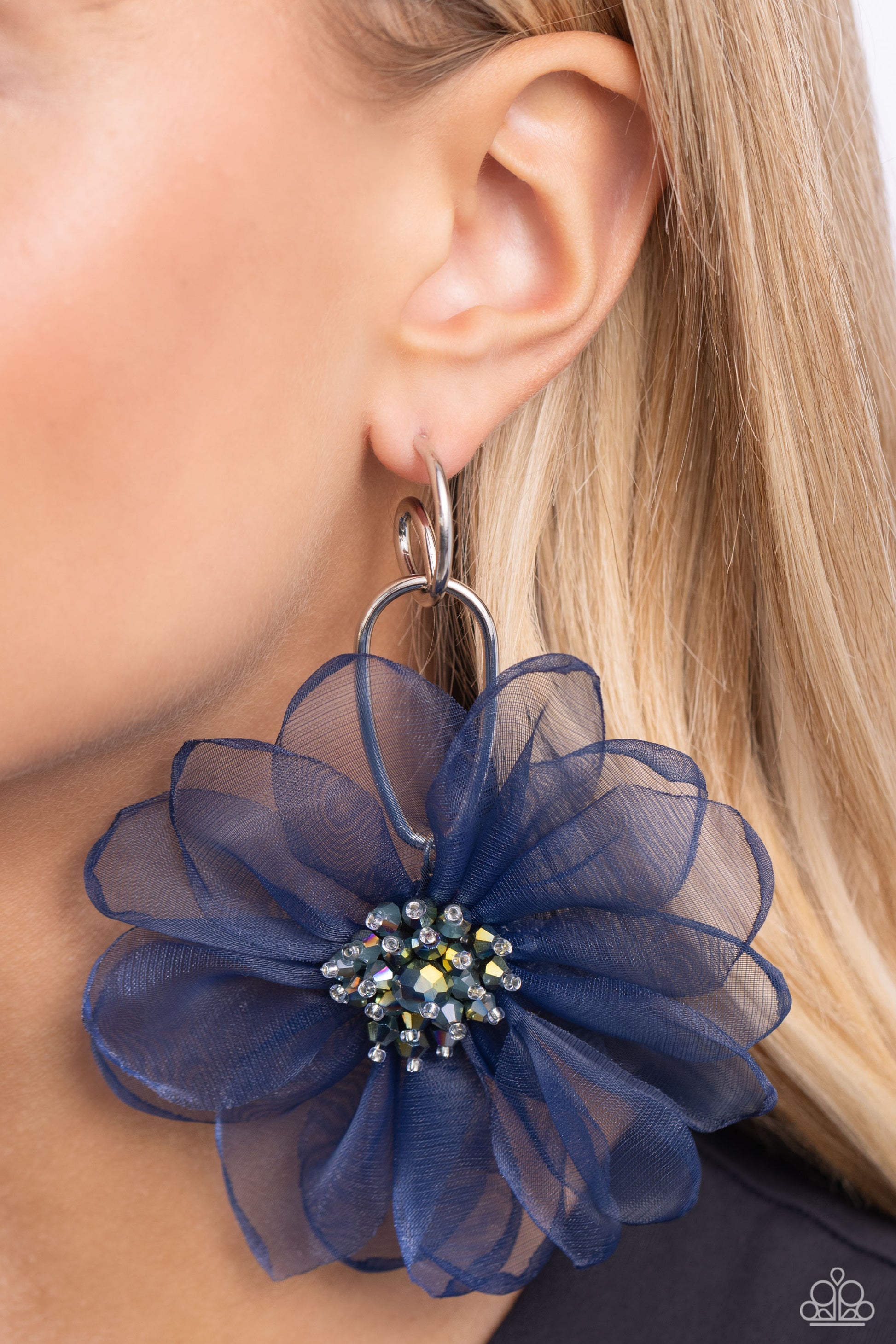 Paparazzi Accessories - Cosmopolitan Chiffon - Blue Earringthat duo of asymmetrical silver hoops link as they tumble from the ear, coalescing into an abstract lure. Attached to the bottom of the elongated display, oversized navy chiffon petals bloom around oil spill-tinted beads, creating a fantastical floral frenzy. Earring attaches to a standard post fitting. Hoop measures approximately 1" in diameter.  Sold as one pair of hoop earrings.