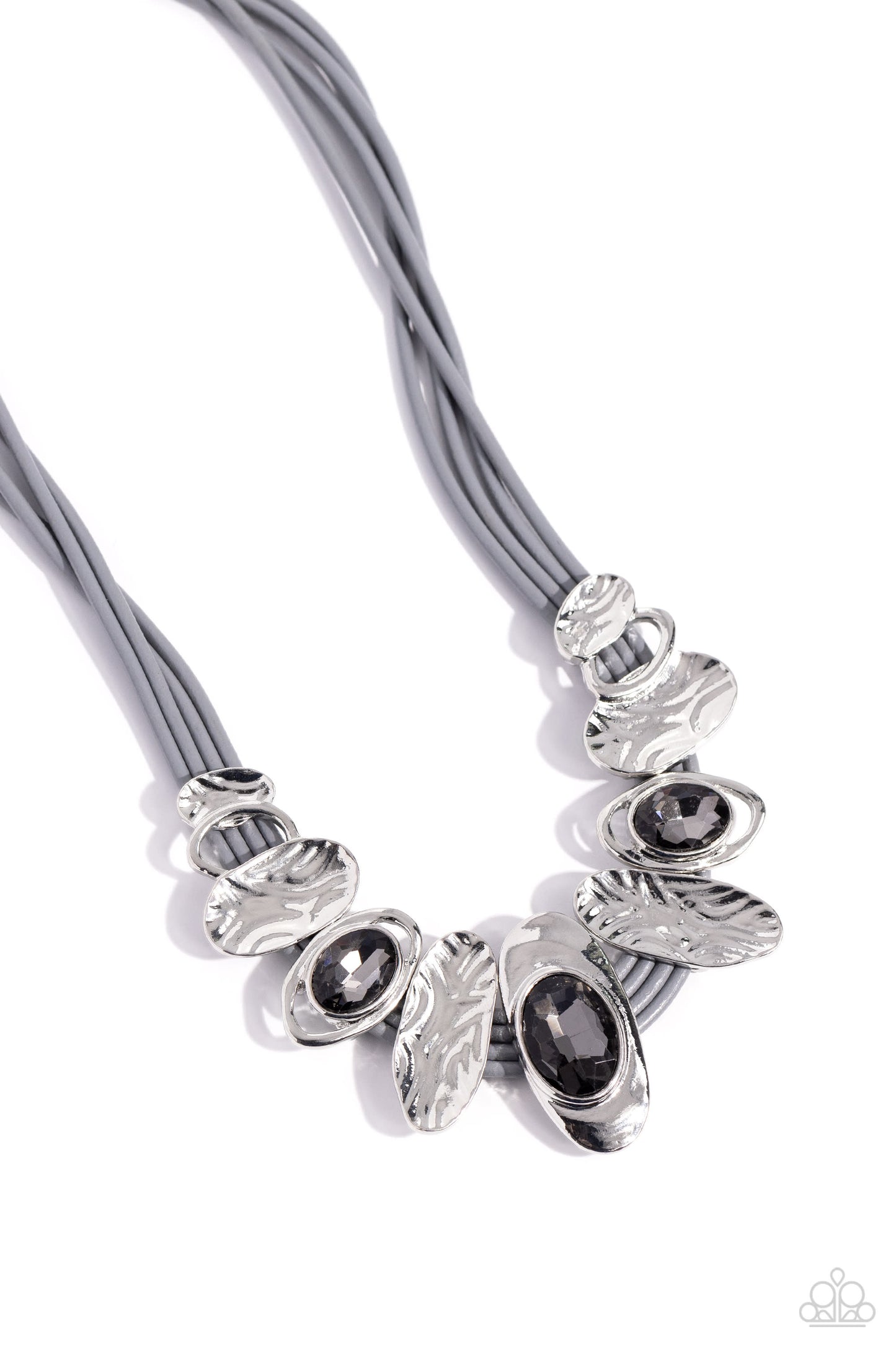 Paparazzi Accessories - Sliding Splendor - Silver Necklaovalfeaturing a lightly hammered sheen, asymmetrical silver ovals, some with airy silhouettes and exaggerated smoky gem centers, give off a hand-made feel as they shift and slide through multiple strands of gray cording for an artisanal design below the collar. Features an adjustable clasp closure.  Sold as one individual necklace. Includes one pair of matching earrings.